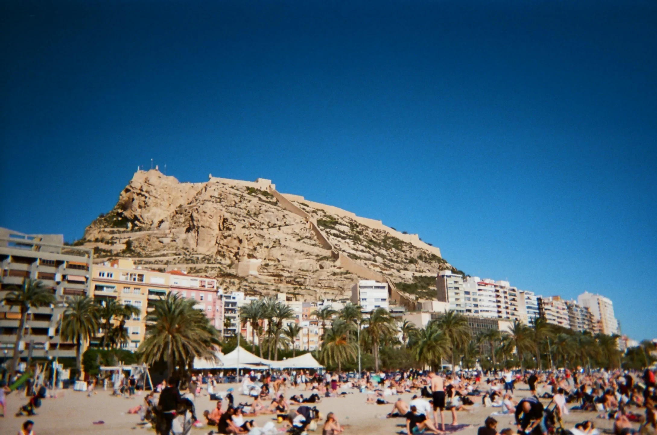 Coastal city and hillside above a crowded beach