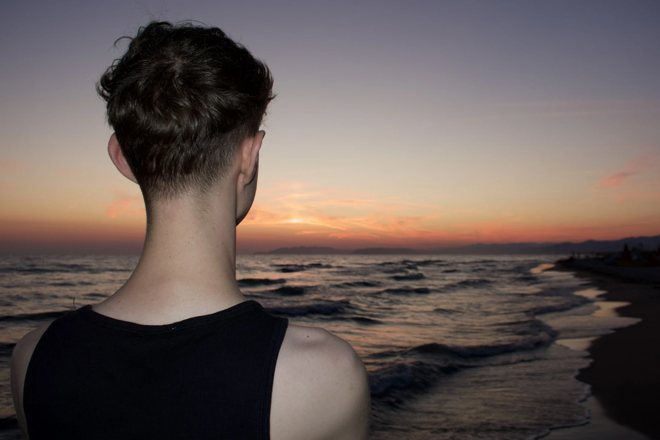 Figure looking toward the sea at sunset