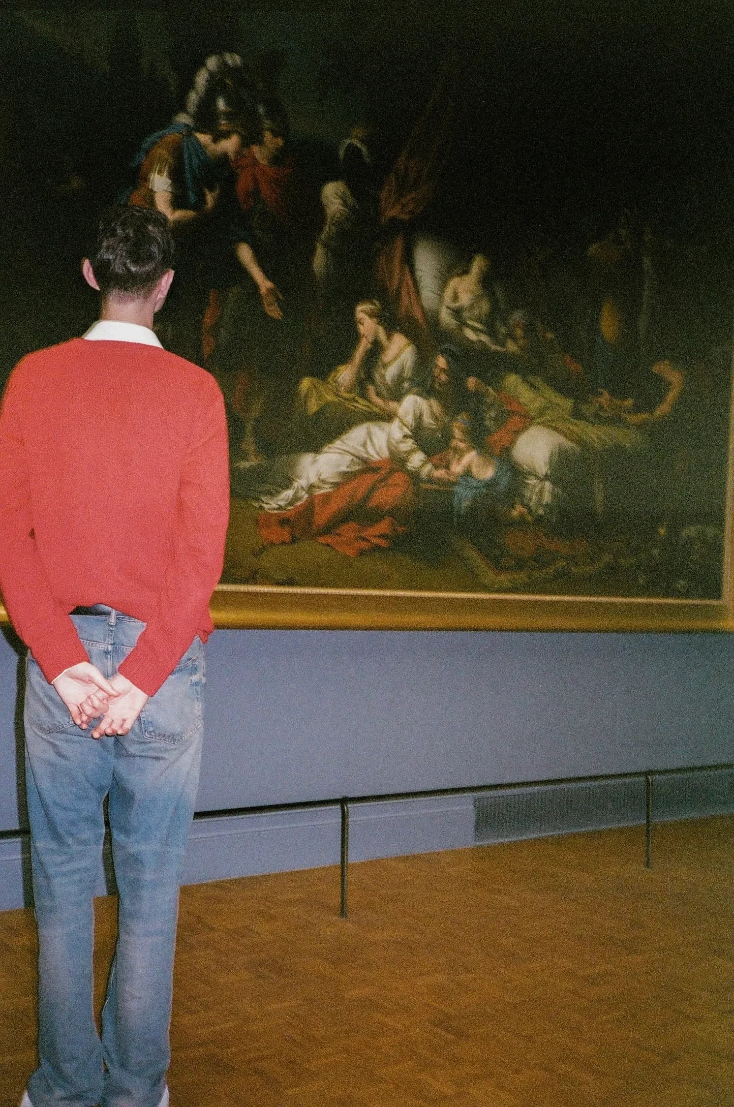Gallery visitor standing before a classical painting