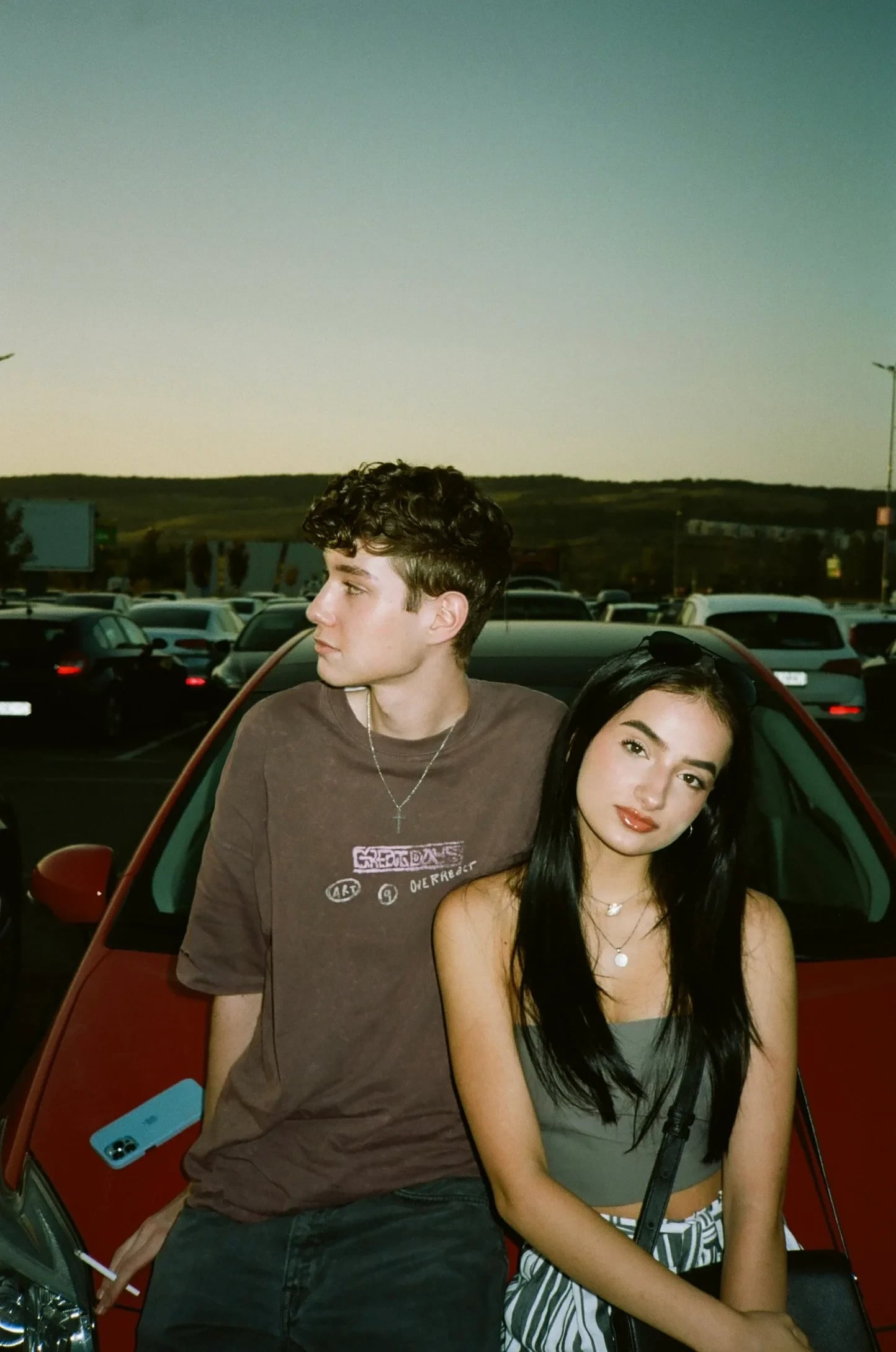 Portrait of two people beside a car