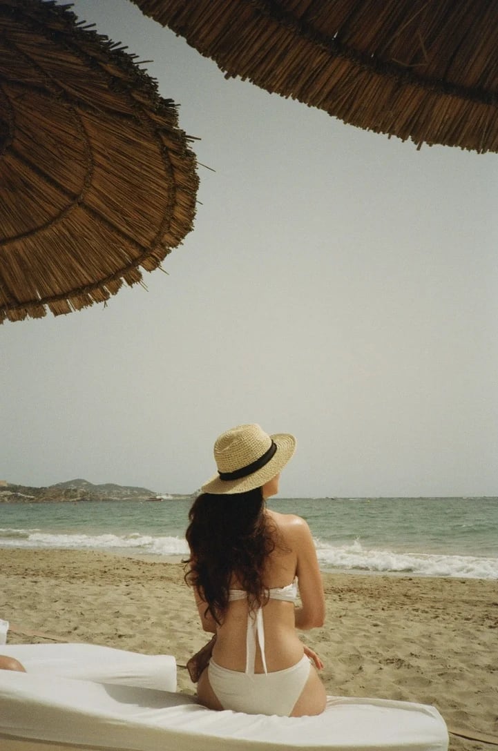 Woman in a sunhat facing the sea