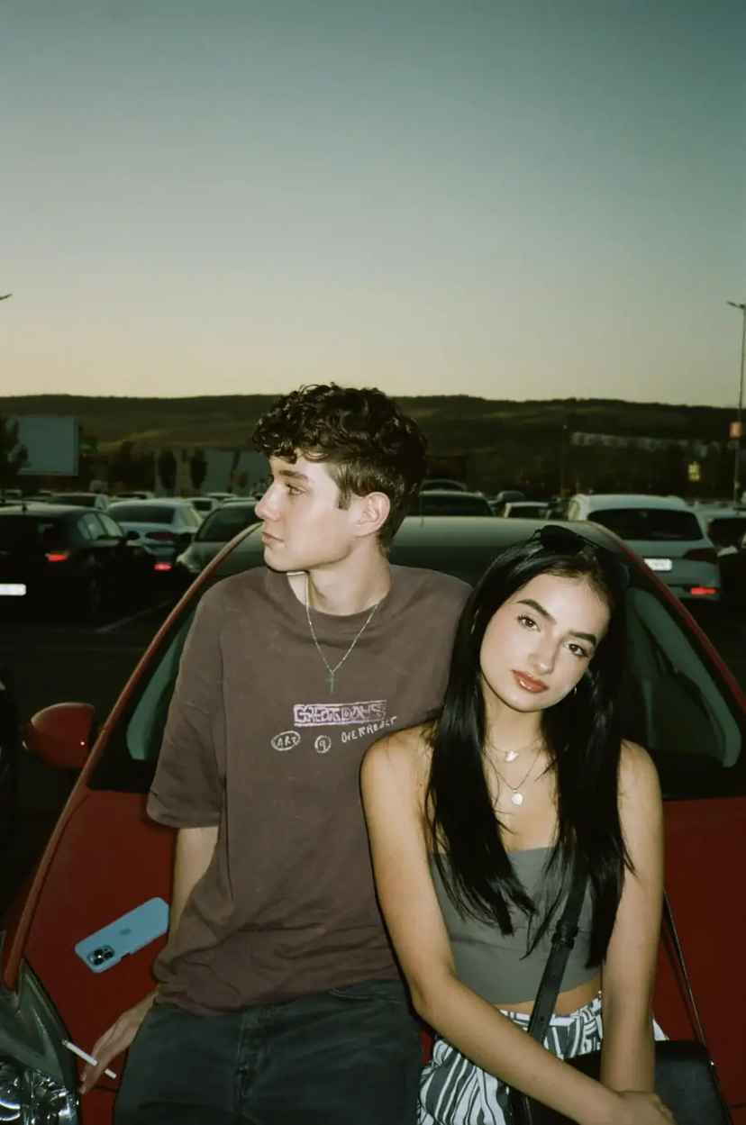 Portrait of two people beside a car — original source