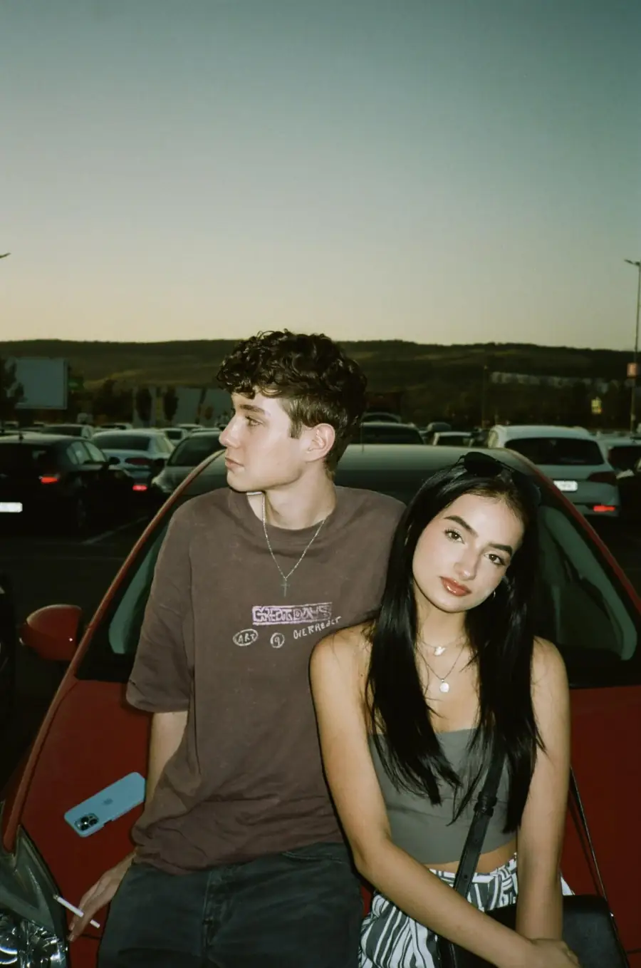 Portrait of two people beside a car — original source